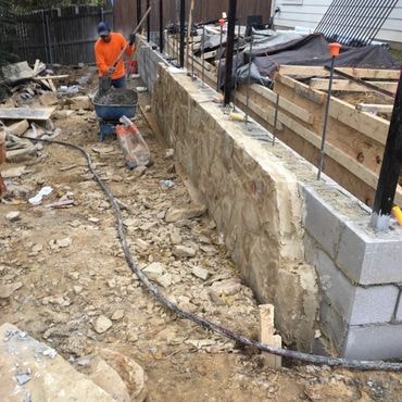 Concrete block retaining wall with stone veneer in a residential landscape